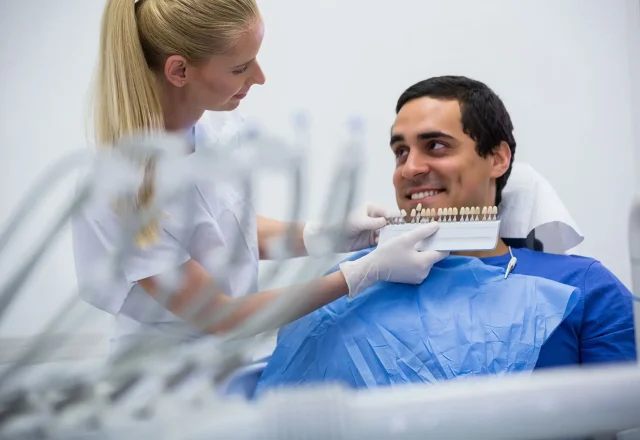 dentist-examining-female-patient-with-teeth-shades(1) 1